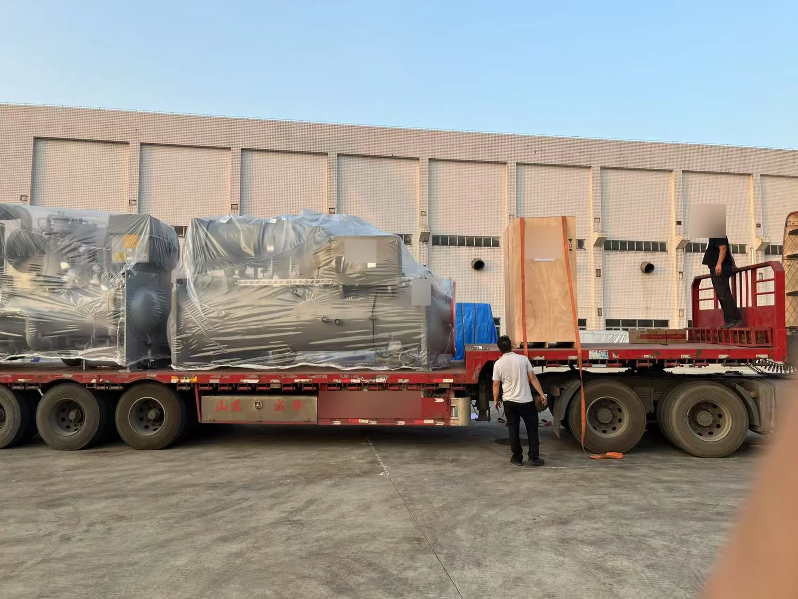 Wrapped Hitachi chiller equipment loaded on a transport trailer for the Thaixing Circuits supply project
